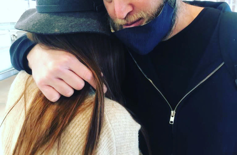 THE WRITER embraces her husband as she sheds tears at the airport. (photo credit: HADASSAH CHEN)