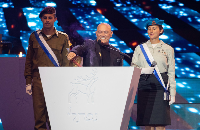 Israeli singer Shlomi Shabat lights a torch during the 73rd anniversary Independence Day ceremony, held at Mount Herzl, Jerusalem on April 14, 2021.  (credit: YONATAN SINDEL/FLASH 90)