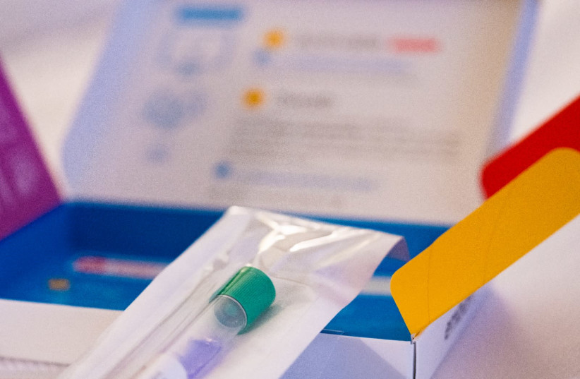 HOME DNA testing kit, with a saliva (spit or cheek swab) tube collector and return shipping box.  (photo credit: TONY WEBSTER/FLICKR)