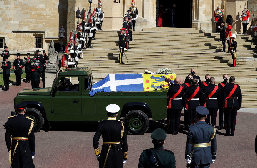 The coffin of Britain's Prince Philip, husband of Queen Elizabeth, who died at the age of 99, is taken from the hearse, a specially modified Land Rover, to be carried into St. George's Chapel for a funeral service, in Windsor, Britain, April 17, 2021. (credit: KIRSTY WIGGLESWORTH/REUTERS)