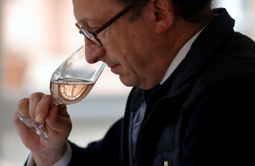 A man is seen smelling champagne at a wine tasting session in France on April 14, 2021. (photo credit: PASCAL ROSSIGNOL/REUTERS)