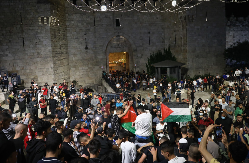 Arabs wave Palestinians flags at Damascus Gate in Jerusalem's Old City, during the holy Muslim month of Ramadan, April 25, 2021. (credit: NOAM REVKIN FENTON/FLASH90)