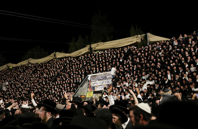 Jewish worshippers sing and dance as they stand on tribunes at the Lag B'Omer event in Mount Meron on April 29, 2021  (credit: REUTERS/STRINGER)