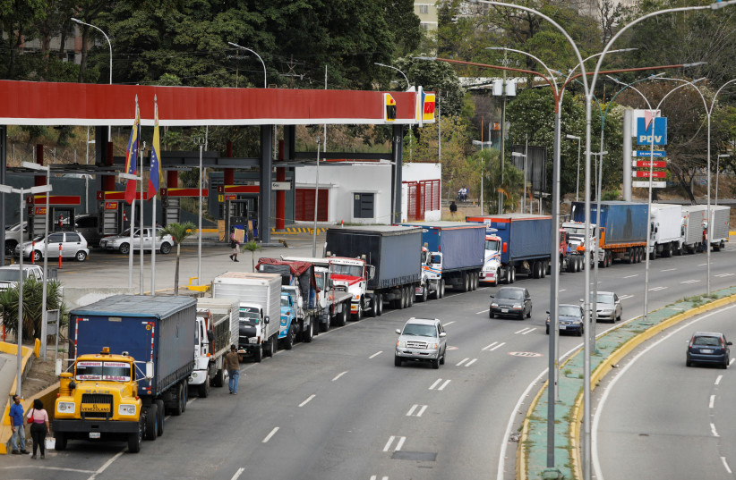 Trailer trucks line up along an avenue to fill up their tanks at a gas station as part of a growing diesel shortage, in Caracas, Venezuela March 5, 2021.  (photo credit: REUTERS/LEONARDO FERNANDEZ VILORIA)