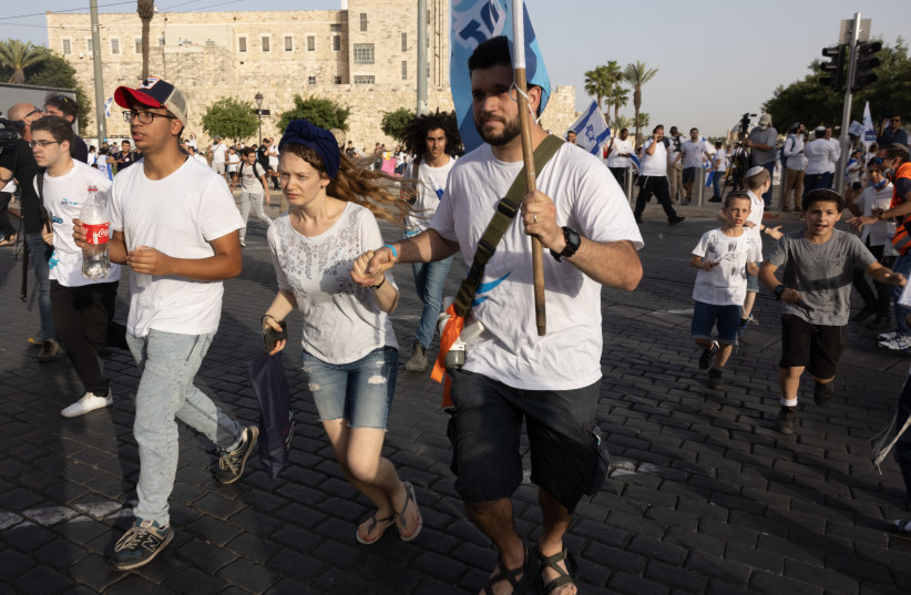 Israelis take cover as a siren sounds warning of incoming rockets from the Gaza Strip, during Jerusalem day, in Jerusalem, May 10, 2021.  (photo credit: NATI SHOHAT/FLASH90)