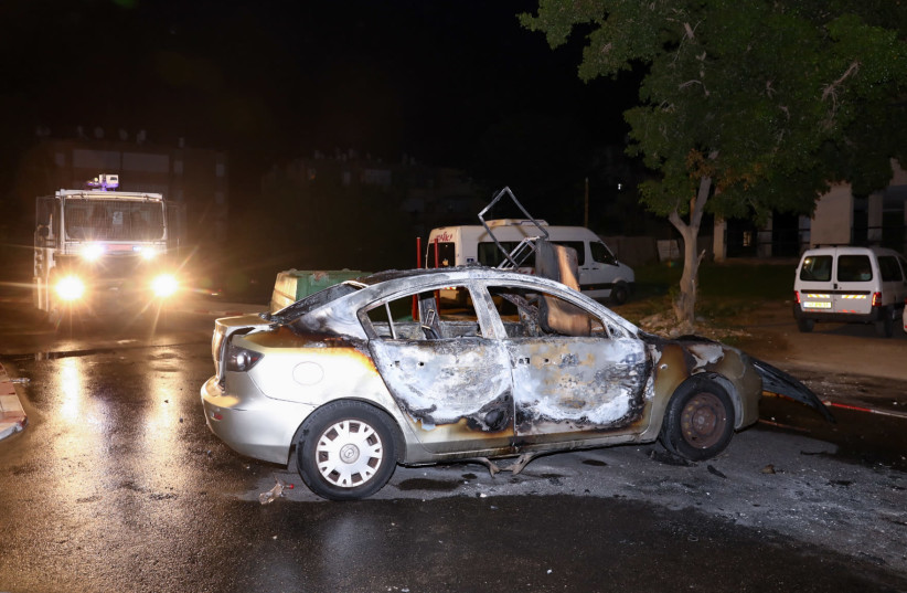 A car set on fire by Israeli Arab residents during riots and clashes between Arab and Jewish residents, in the central Israeli town of Lod, on May 12, 2021.  (photo credit: YOSSI ALONI/FLASH90)