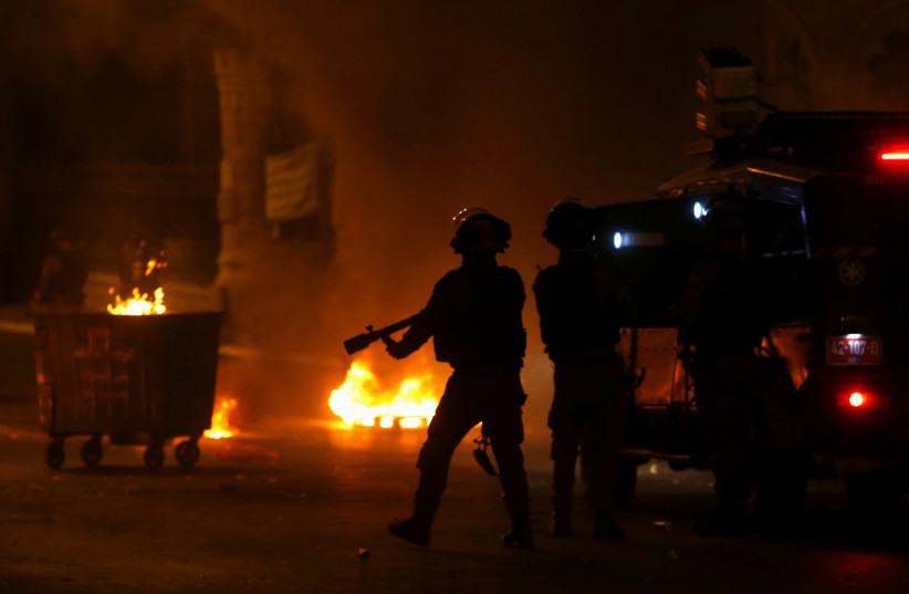 Des Palestiniens courent alors qu'un véhicule militaire israélien tire des bombes lacrymogènes lors d'une manifestation anti-israélienne contre les tensions à Jérusalem, à Bethléem, en Cisjordanie occupée par Israël, le 10 mai 2021 (Crédit photo: MUSSA QAWASMA / REUTERS)