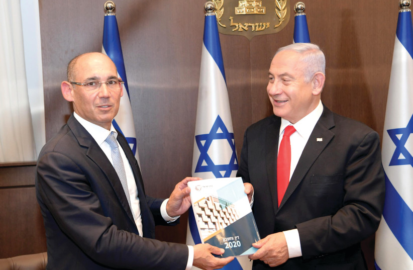 Bank of Israel Governor Prof. Amir Yaron presents the central bank’s Annual Report for 2020 to Prime Minister Benjamin Netanyahu on April 6. (photo credit: AMOS BEN-GERSHOM/GPO)