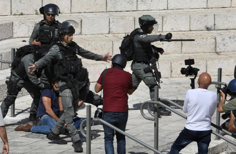 Des agents de la police des frontières d'Israël arrêtent un manifestant à la porte de Damas (crédit : MARC ISRAEL SELLEM)