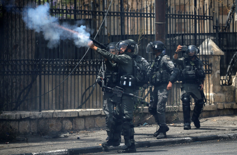 A member of Israeli border police fires tear gas canisters to disperse Palestinian demonstrators during an anti-Israel protest, in Bethlehem in the West Bank May 21, 2021. (photo credit: MUSSA QAWASMA/REUTERS)
