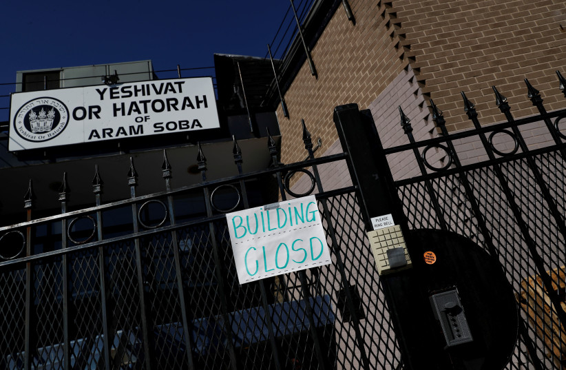 A sign is seen at a locked gate to the closed Yeshivat Or Hatorah school amid the coronavirus disease (COVID-19) outbreak in the Sheepshead Bay section of the Brooklyn borough of New York, US, October 6, 2020. (credit: REUTERS/SHANNON STAPLETON)