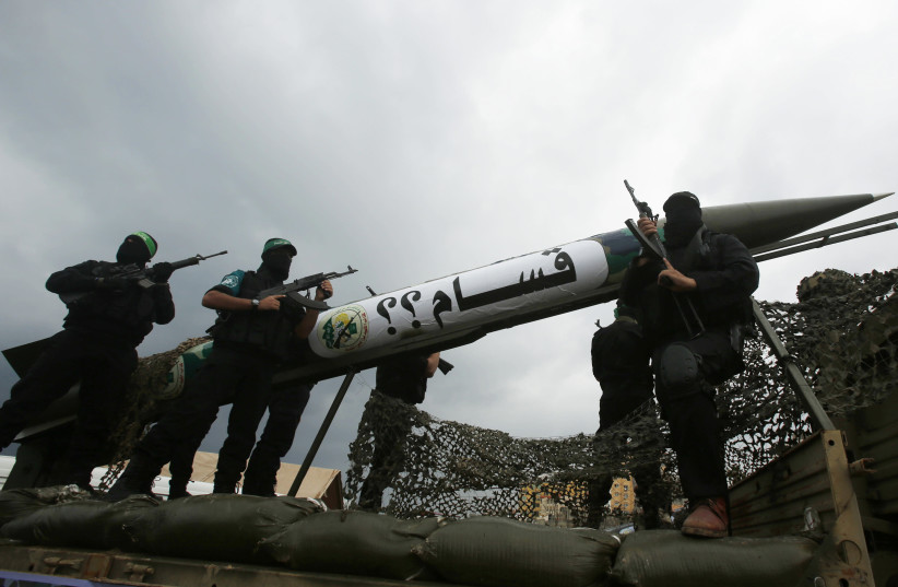 AL-QASSAM BRIGADES members display a homemade Qassam rocket during a Gaza City military parade (credit: SUHAIB SALEM/REUTERS)