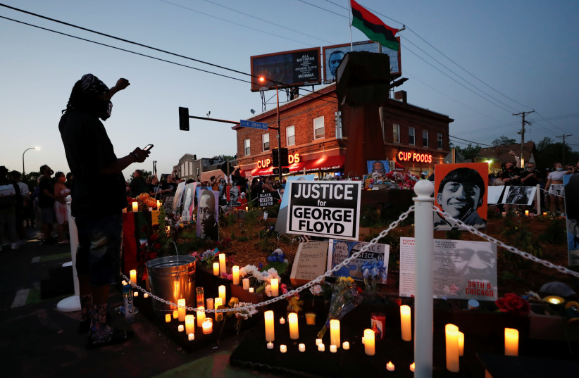 A person raises his fist at a memorial during a Celebration of Life festival in honor of George Floyd, who was killed by Minneapolis police one year ago, at George Floyd Square in south Minneapolis, Minnesota, US, May 25, 2021. (credit: ERIC MILLER/REUTERS)