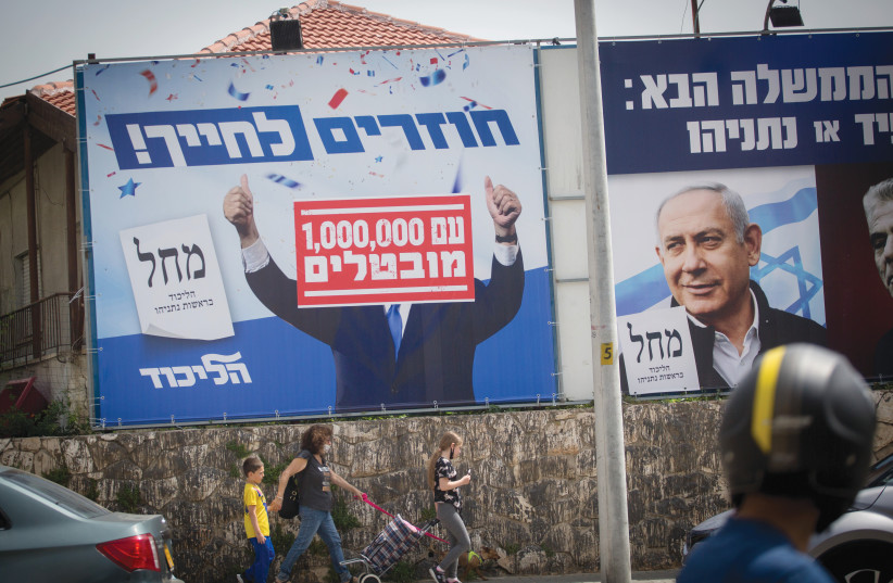 A LIKUD campaign poster with the slogan “Returning to life” is altered to add “with 1,000,000 unemployed,” in Tel Aviv on March 21, 2021 (credit: MIRIAM ALSTER/FLASH90)