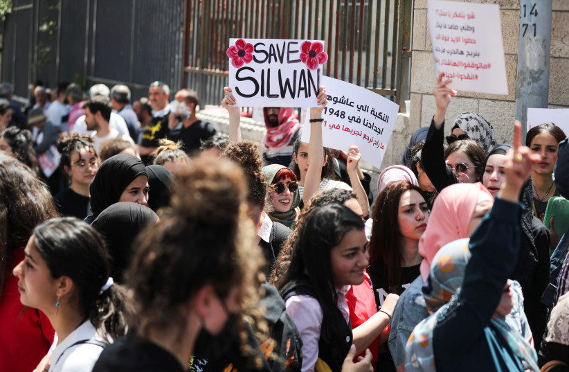Protesters hold placards at a demonstration during a court hearing over the planned eviction of residents from Silwan, a neighborhood of east Jerusalem, near the district court in Jerusalem May 26, 2021. (photo credit: AMMAR AWAD/REUTERS)