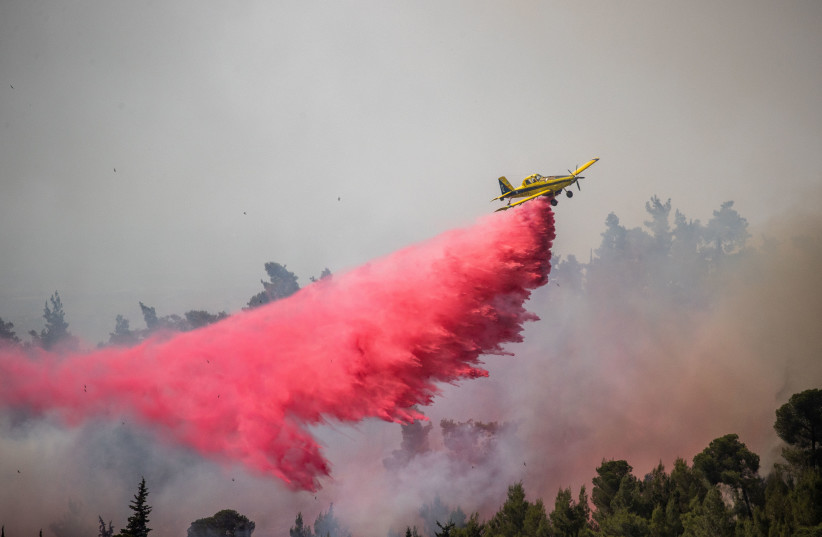 Firefighting planes try to extinguish a large forest fire which broke out near Neve Ilan, outisde of Jerusalem, June 09, 2021. (photo credit: YONATAN SINDEL/FLASH 90)