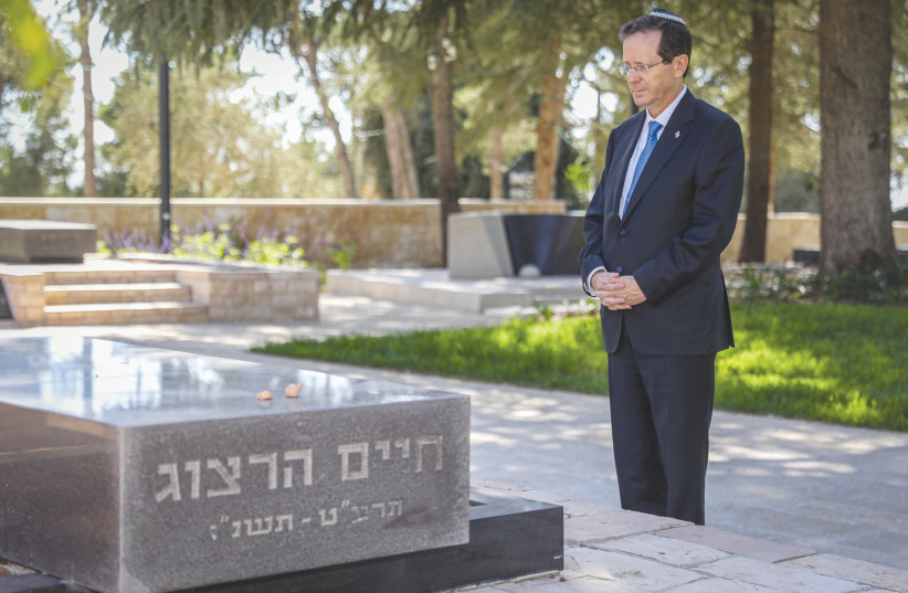 NEWLY ELECTED President Isaac Herzog visits the grave of his father, Chaim Herzog, at Mount Herzl Cemetery in Jerusalem earlier this month. (credit: NOAM REVKIN FENTON/FLASH90)