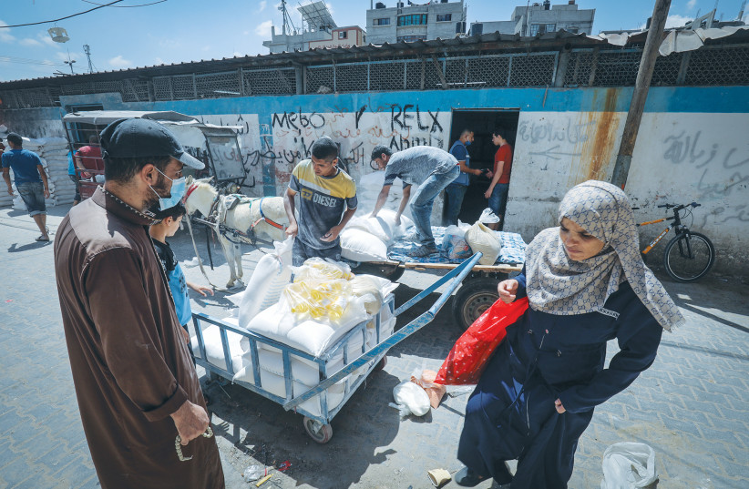 PALESTINIANS RECEIVE food aid at a United Nations distribution center in the Rafah refugee camp in the southern Gaza Strip, on Monday. (photo credit: ABED RAHIM KHATIB/FLASH90)