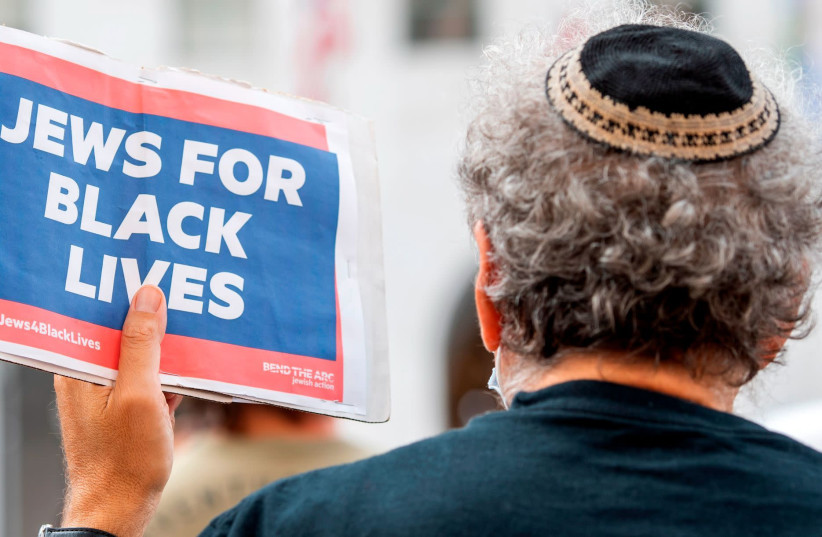 A kippah-clad man holds a sign reading "Jews for Black Lives" at the weekly Black Lives Matter "Jackie Lacey Must Go!" protest in front of the Hall of Justice in Los Angeles, Sept. 9, 2020. (photo credit: VALERIE MACON / GETTY IMAGES NORTH AMERICA / AFP)