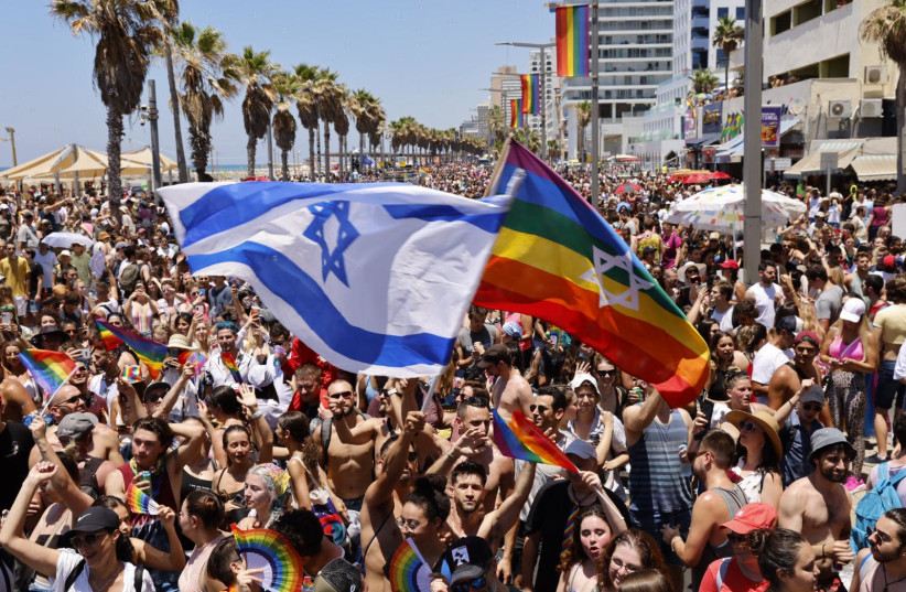 Israeli flag and rainbow flag being waved at Tel Aviv Pride Parade, June 25 2021 (credit: GUY YECHIELY)