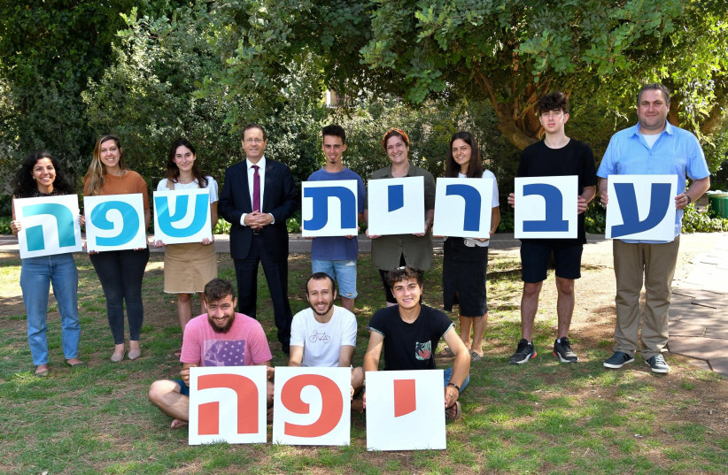 Isaac Herzog with Jewish Agency shlichim holding up signs that translate into ''Hebrew is a Beautiful Language.'' (credit: ZOOG PRODUCTION)