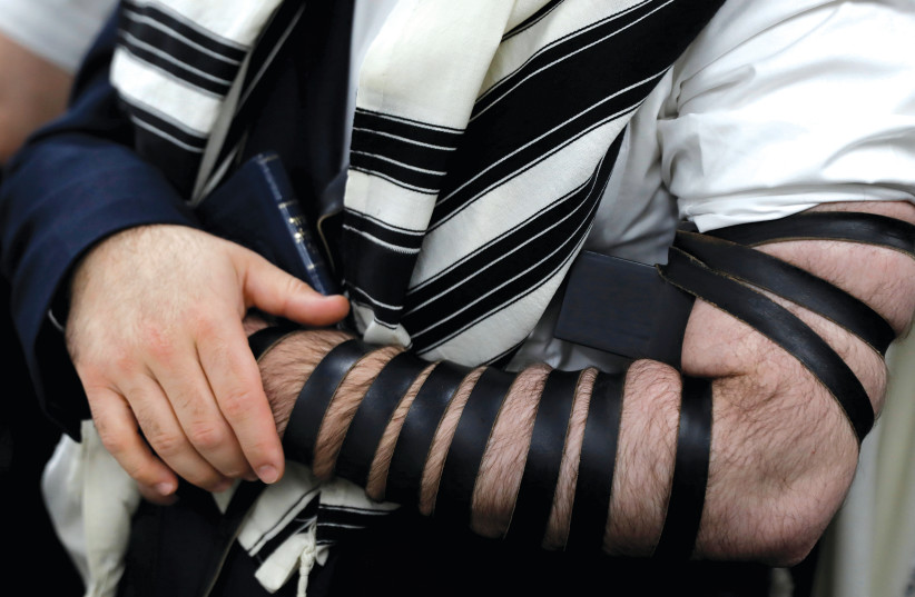 An illustrative photograph of a man wearing tefillin (credit: ANDREW KELLY / REUTERS)