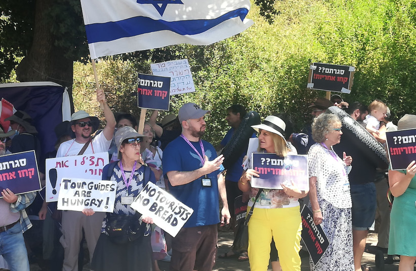 Israeli tour guides are seen protesting outside the Knesset as low tourism and no government benefits puts them in crisis, on July 6, 2021. (credit: ZEV STUB)