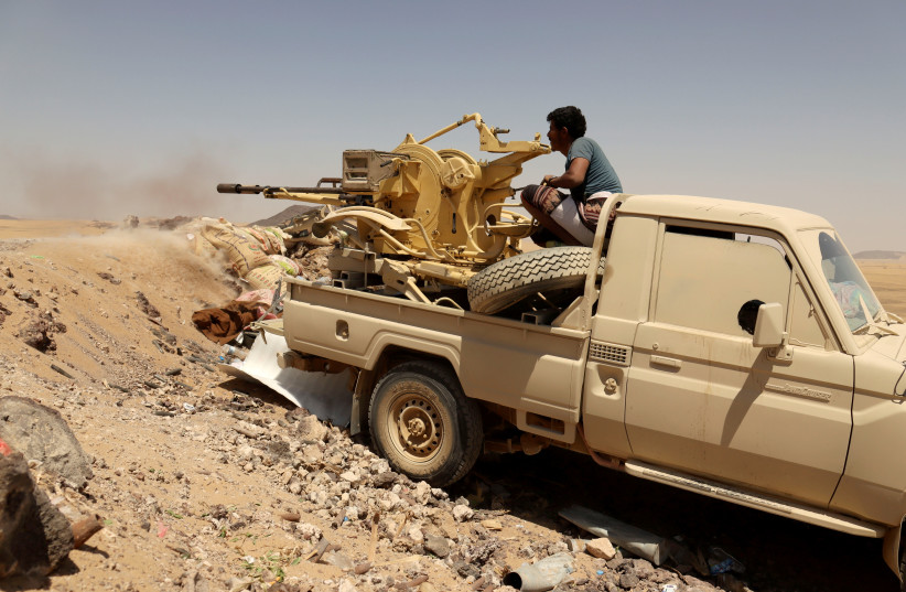 A YEMENI government fighter fires at Houthi fighters in Marib, Yemen, March 28. (photo credit: ALI OWIDHA/ REUTERS)