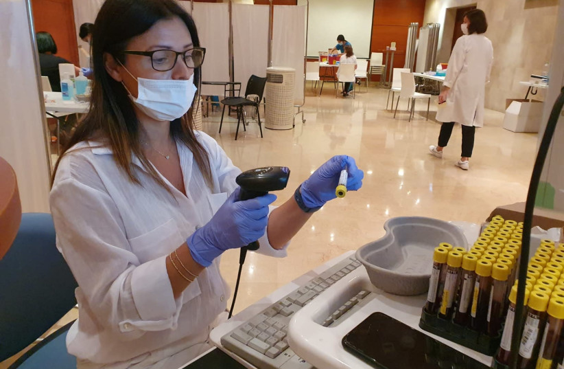 Medical personnel is seen examining blood samples at Rambam Health Care Campus in Haifa, Israel. (photo credit: RAMBAM HEALTHCARE CAMPUS)