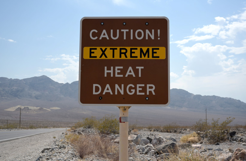  A sign warns of extreme heat in Death Valley, California, US, July 11, 2021 (photo credit: REUTERS/BRIDGET BENNETT/FILE PHOTO)