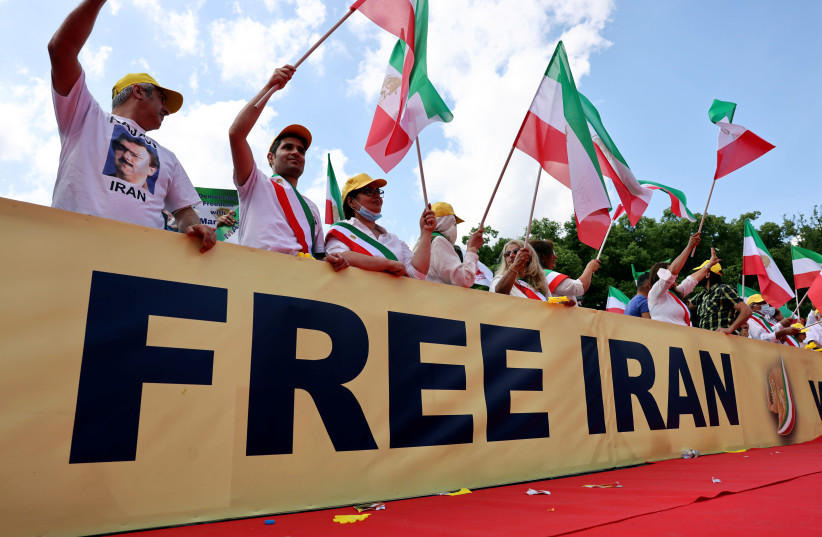 Supporters of the National Council of Resistance of Iran (NCRI) gather to protest against the government in Teheran and the use of the death penalty in Iran, in front of the Brandenburg Gate in Berlin, Germany, July 10, 2021. (photo credit: REUTERS/CHRISTIAN MANG)