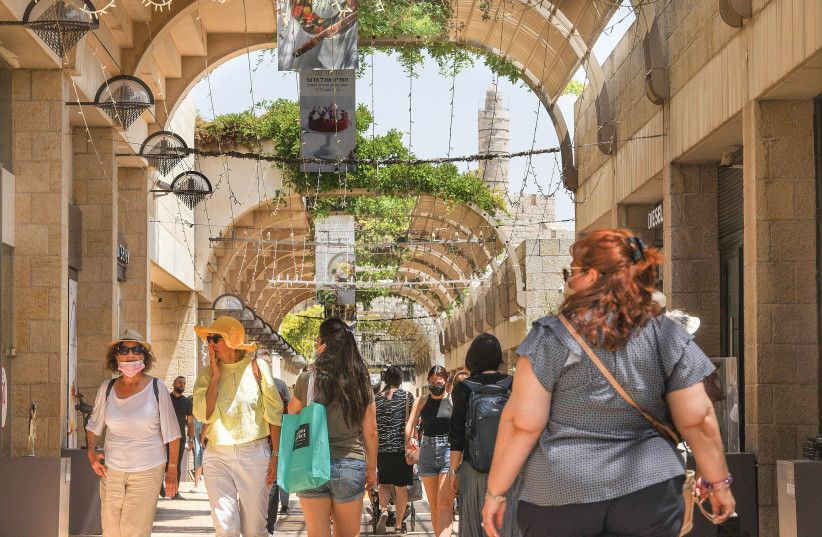 MASKED AND unmasked people walk along Jerusalem’s Mamilla pedestrian mall yesterday. (credit: MARC ISRAEL SELLEM/THE JERUSALEM POST)