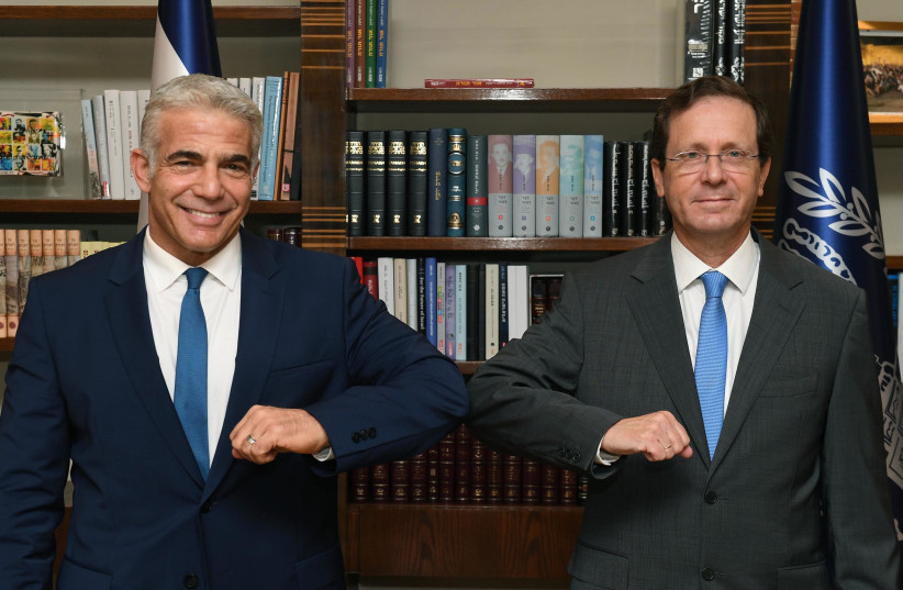 Foreign Minister Yair Lapid and President Isaac Herzog at their first work meeting, July 18, 2021. (photo credit: MARC NEYMAN/GPO)