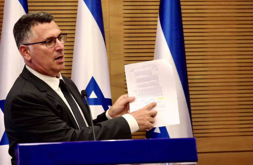 Justice Minister Gideon Sa'ar is seen pointing at Benjamin Netanyahu's signature on a Likud-sponsored bill to stop Ehud Olmert from being able to form a government, in the Knesset on July 26, 2021. (credit: MARC ISRAEL SELLEM/THE JERUSALEM POST)