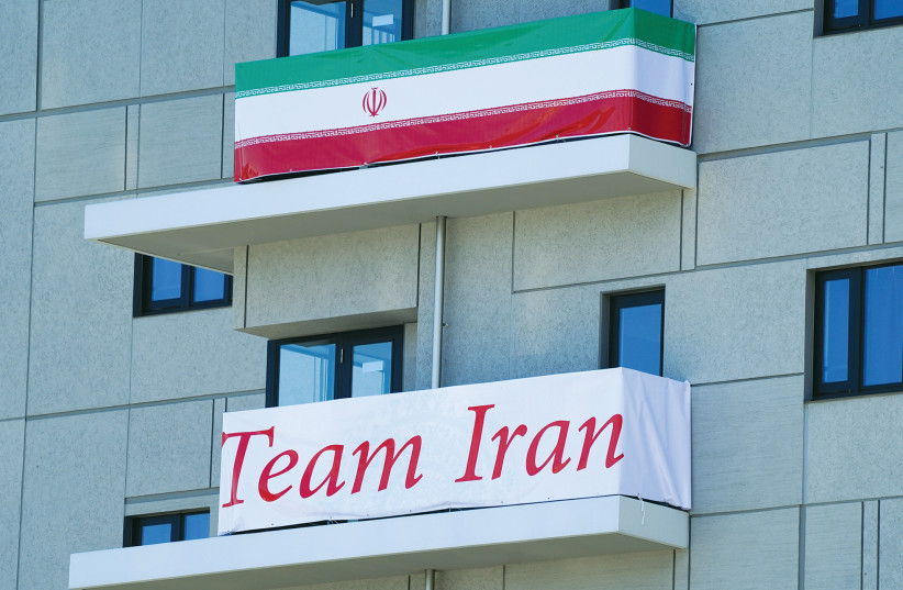 A flag and banner of the Iranian Olympic team hang at an apartment building in the athletes’ village for the Tokyo 2020 Olympic Games last week. (photo credit: NAOKI OGURA/REUTERS)