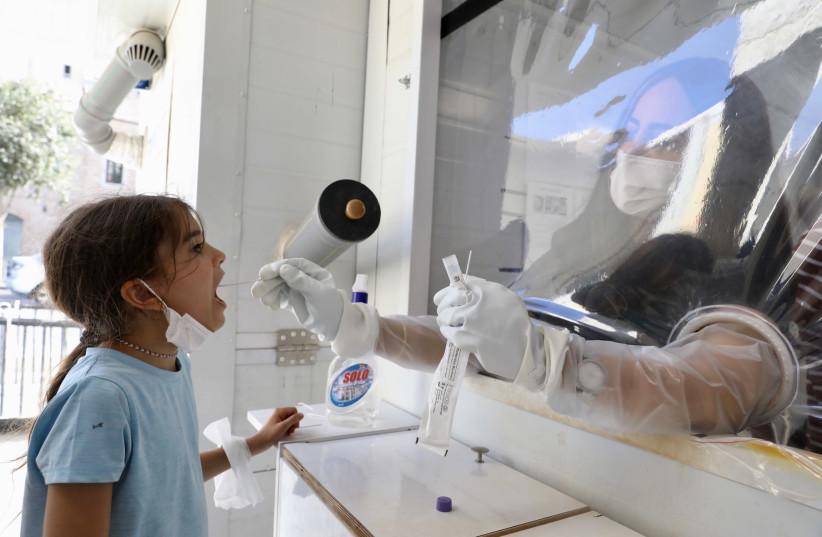 A schoolgirl gets a corona test at the Meuchedet Medical Center in Jerusalem on July 22. (credit: MARC ISRAEL SELLEM)