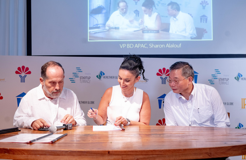 Sharon Alalouf, VP Business development APAC, Cellwize (center) signs her company distribution agreement with eFormula Technology within IP² Plus innovation program. (photo credit: NATI LEVI)