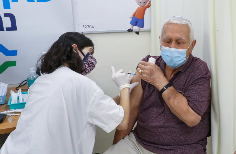 An elderly Israeli is seen receiving the third COVID-19 booster shot at a Clalit clinic in Jerusalem, on August 1, 2021. (credit: MARC ISRAEL SELLEM/THE JERUSALEM POST)