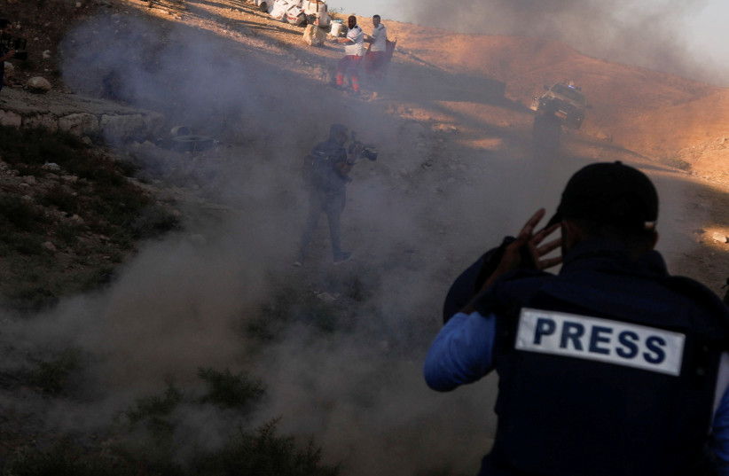 Paramedics and journalists during clashes between Israeli forces and Palestinian demonstrators protesting against Israeli settlements, near Tubas in the West Bank July 27, 2021.  (photo credit: REUTERS/RANEEN SAWAFTA)