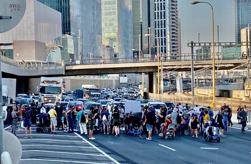 Disability Rights activists block Ayalon Highway to protest new state budget, August 5, 2021 (photo credit: AVSHALOM SASSONI/MAARIV)