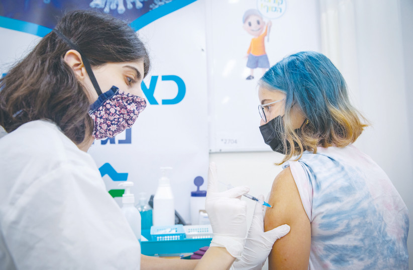  YOUTH RECEIVE their COVID-19 vaccine at a Clalit center in Jerusalem in August. (photo credit: OLIVIER FITOUSSI/FLASH90)