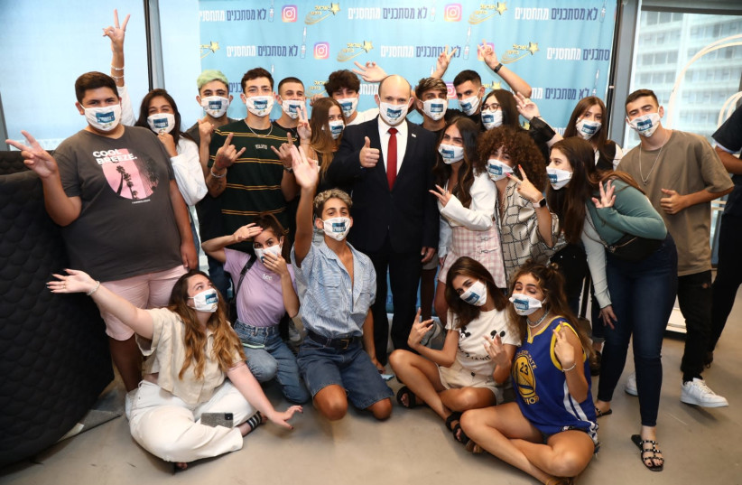 Prime Minister Naftali Bennett met with young Israeli social media influencers to encourage Israeli youths to get the vaccine jab. (photo credit: ARIEL ZANDBERG)