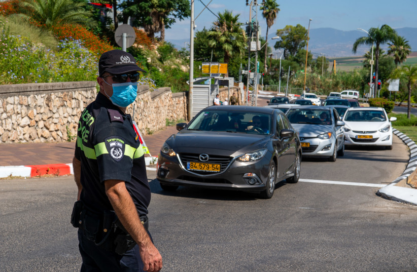 Israeli police officers guard at the entrance to a neighborhood in the northern Israeli city of Tiberias, June 24, 2020, during a closure on some neighborhood in the city following the spread of the Coronavirus.  (photo credit: BASEL AWIDAT/FLASH90)