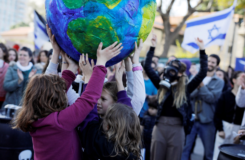 Children hold a globe during a demonstration against Israel's offshore Leviathan natural gas field due to environmental concerns. (photo credit: REUTERS/NIR ELIAS)