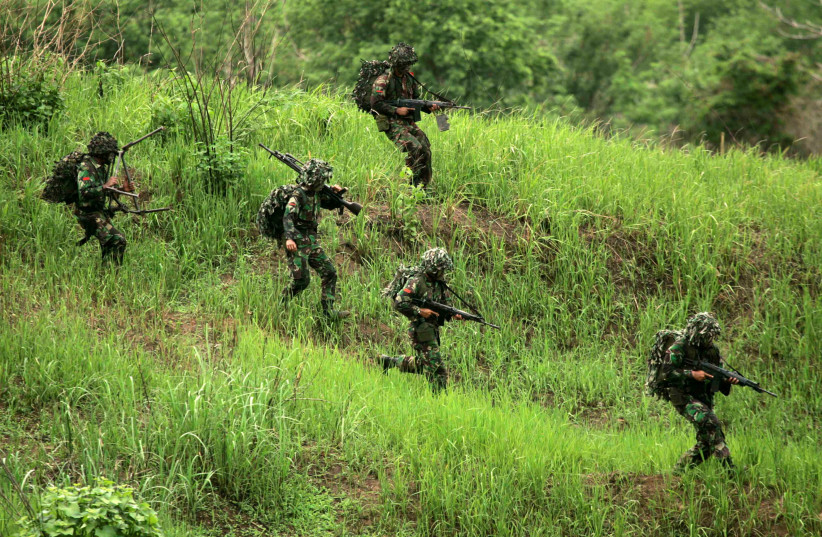 INDONESIAN ARMY soldiers carry their weapons during the last day of a seven-day training exercise in Sukabumi (credit: REUTERS/CRACK PALINGG)