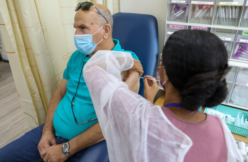 Israeli getting the COVID vaccination at Meuhedet Health Maintenance Organization center at Jerusalem on August 11, 2021. (photo credit: MARC ISRAEL SELLEM)