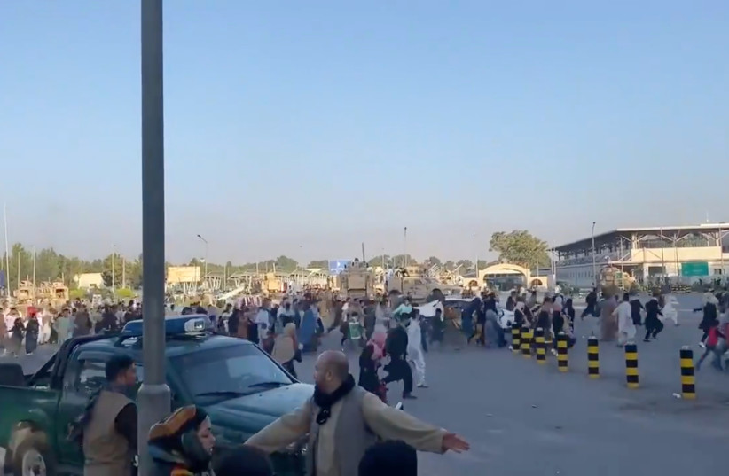  A horde of people run towards the Kabul Airport Terminal, after Taliban insurgents took control of the presidential palace in Kabul, August 16, 2021, in this still image taken from video obtained from social media (photo credit: Jawad Sukhanyar)