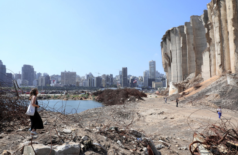  A woman walks on rubble at the site of last year’s Beirut port blast on July 13 (photo credit: MOHAMED AZAKIR/REUTERS)