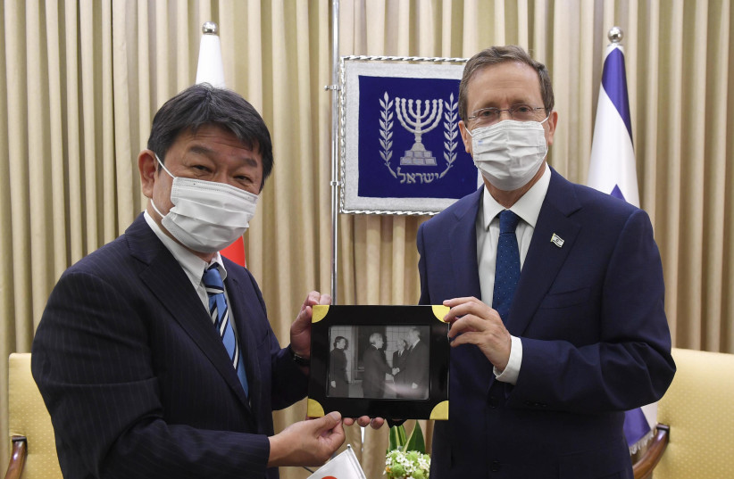  President Herzog receives a photo of his father, president Chaim Herzog, and former Japanese emperor Hirohito. (credit: MARK NYMAN/GPO)