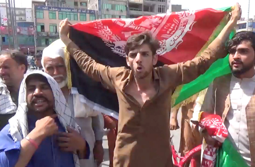  People carry Afghan flags as they take part in an anti-Taliban protest in Jalalabad, Afghanistan August 18, 2021. (photo credit: Pajhwok Afghan News/Handout via REUTERS)